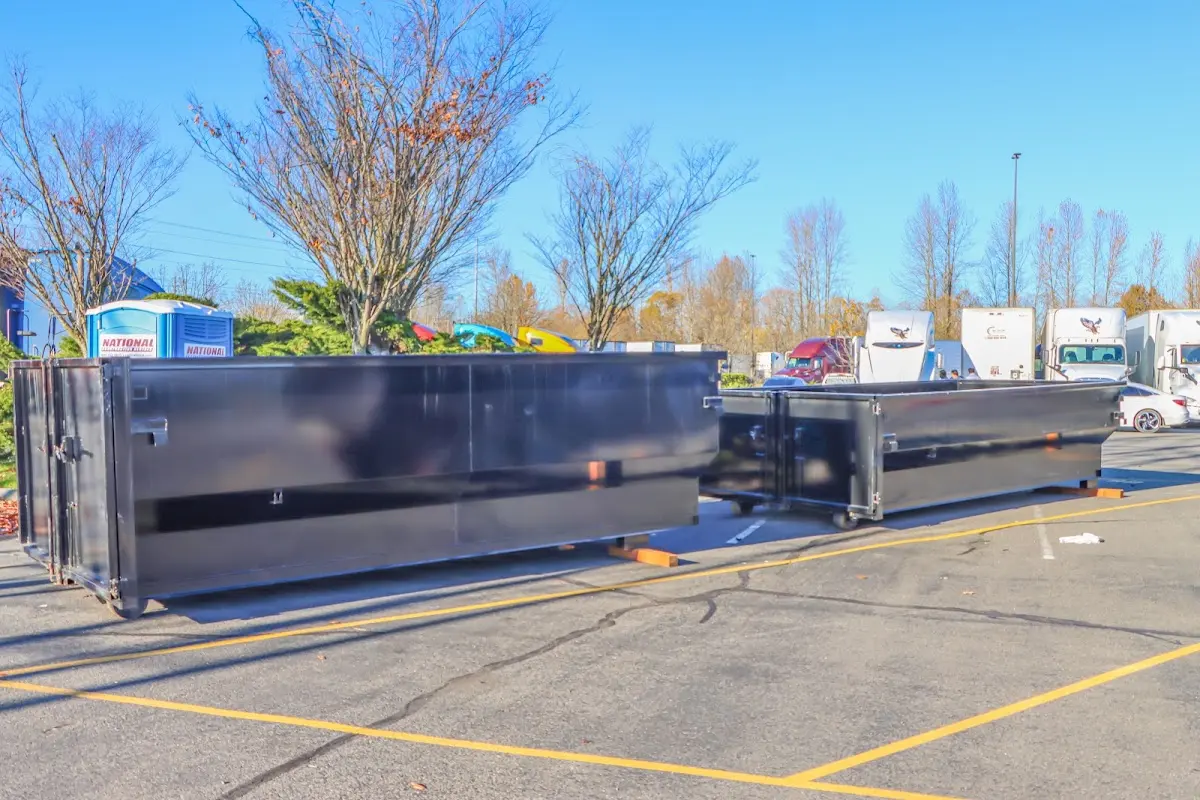Professional dumpster rental service with roll-off container on residential driveway in Derry